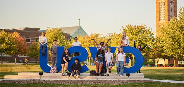 Students posing around a 'GVSU' art installation